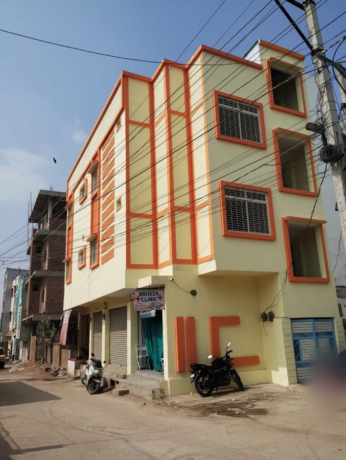 Completed G+2 independent house with orange-trimmed facade and ground-floor shops, built on a 150 square yard plot